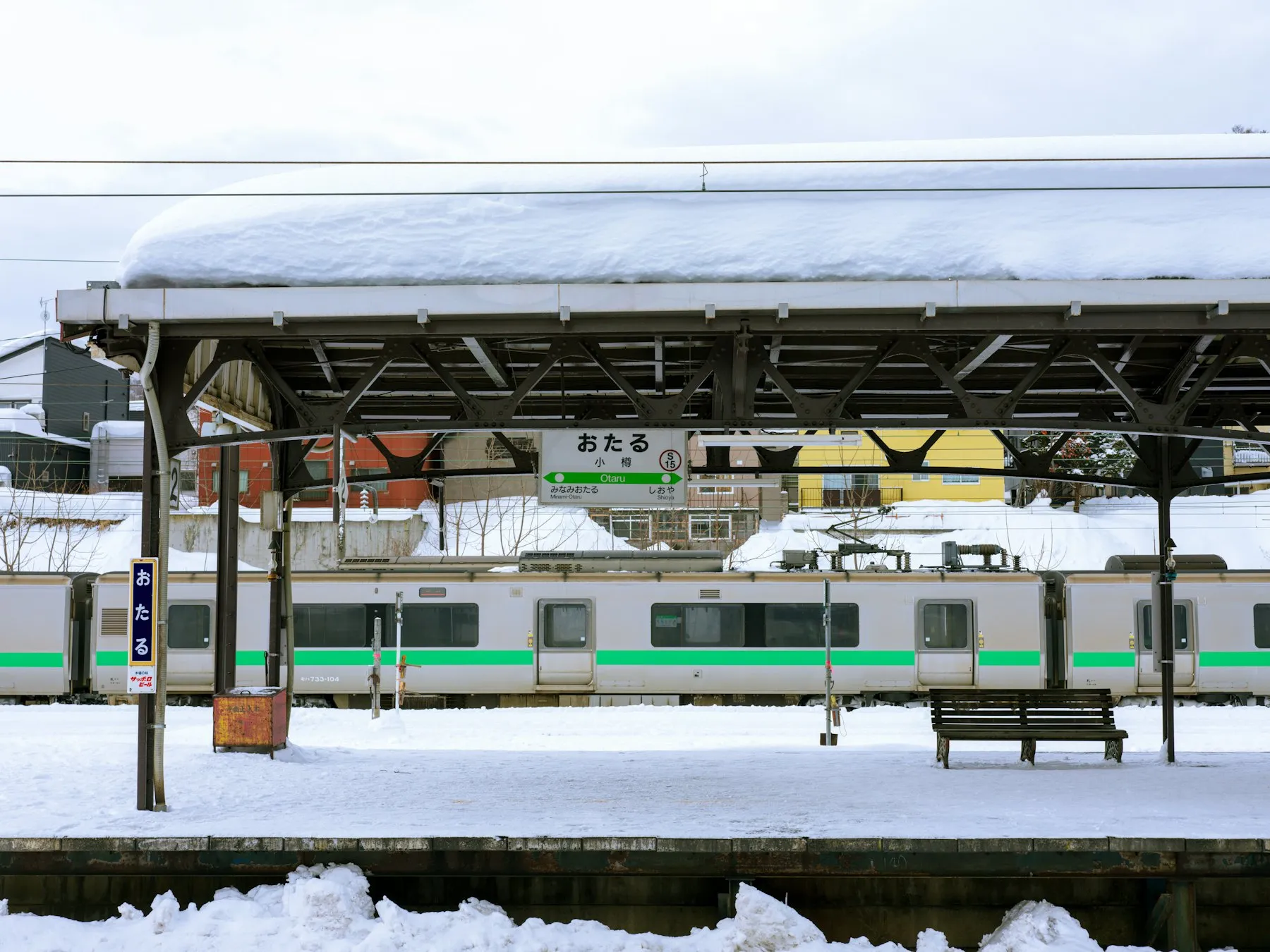 A local train waiting at a snowy station platform